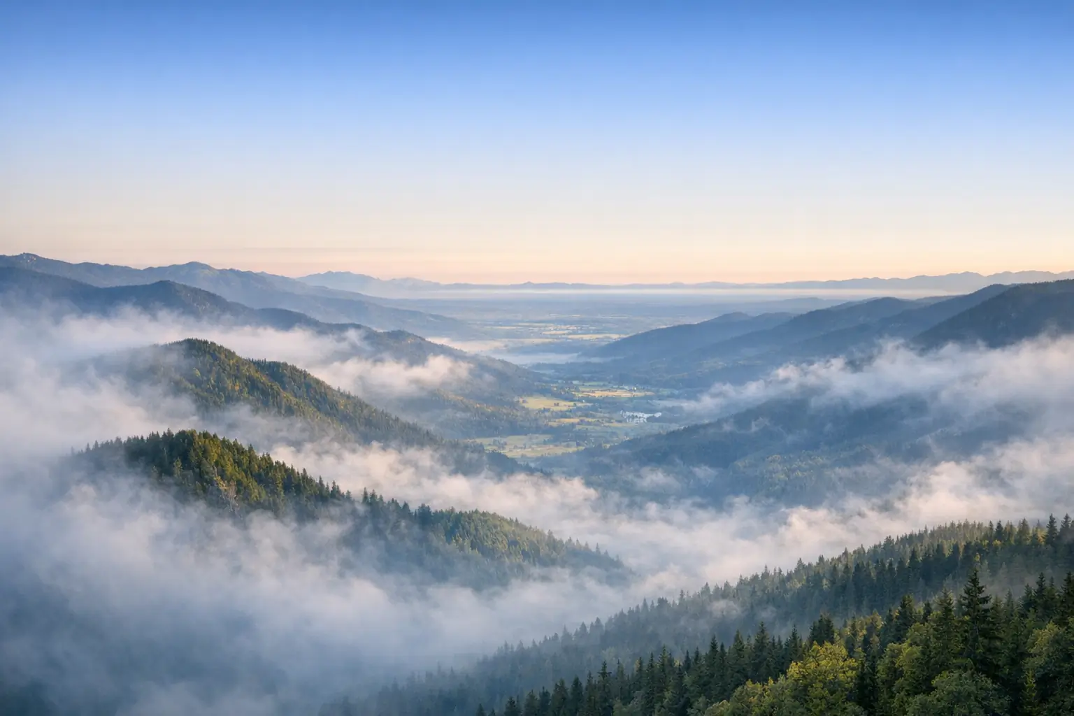 Fog lifting from a mountain valley at dawn, revealing clarity beneath